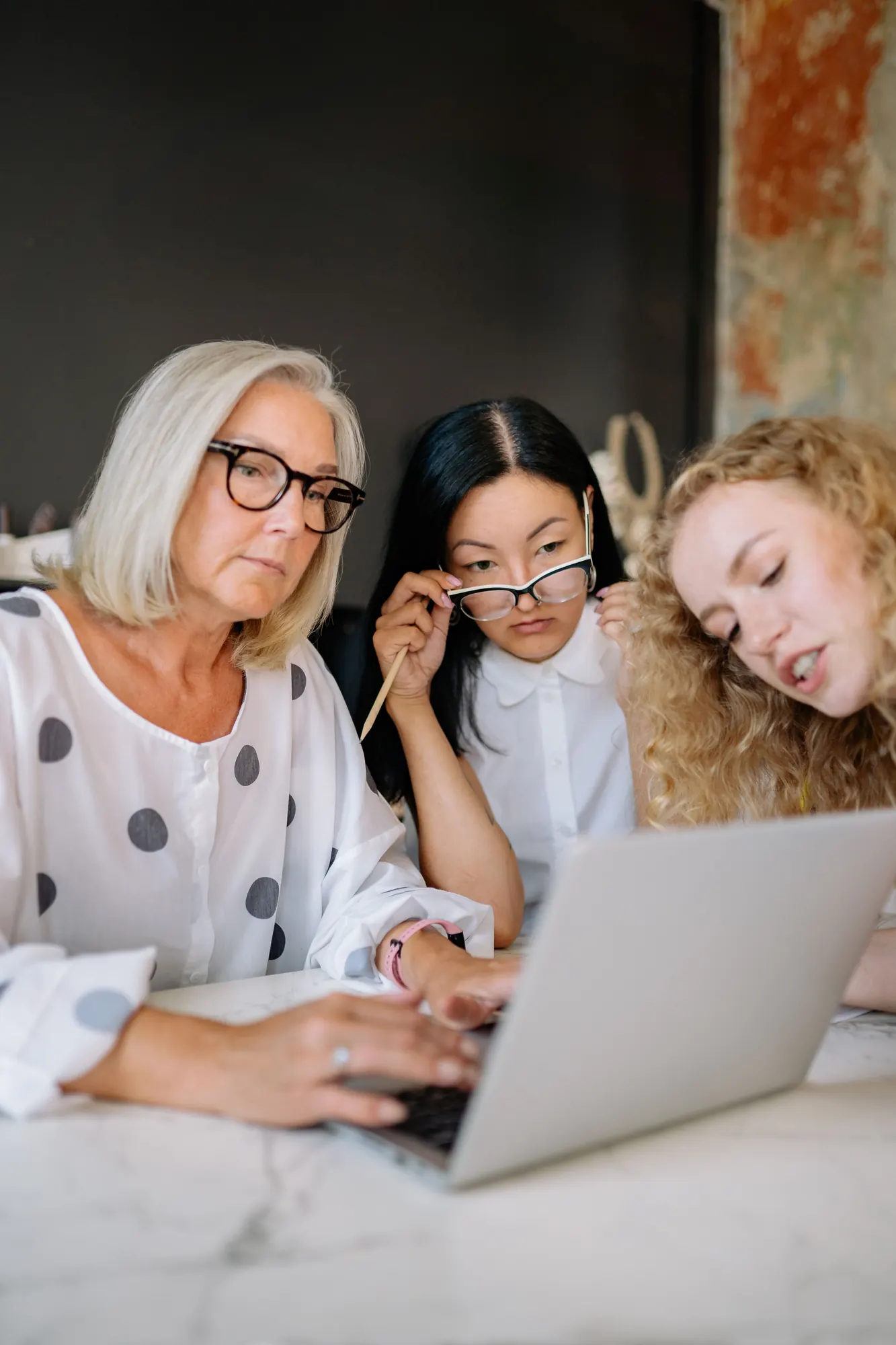Three women working together at a laptop