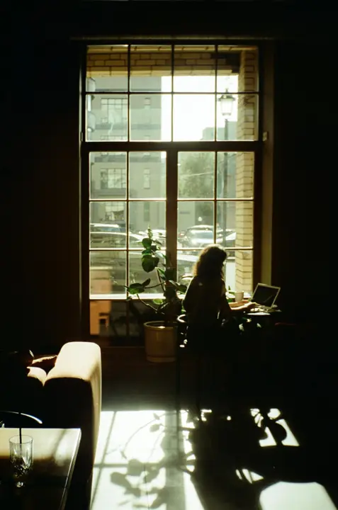 A woman working by a tall window
