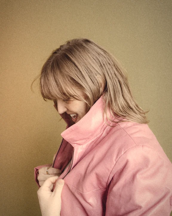 Bonnie laughing in a pink leather jacket